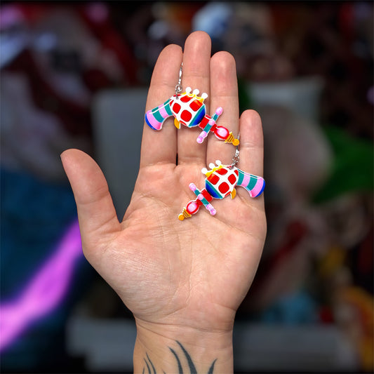 Hand holding Killer Klowns from Outer Space alien ray gun horror resin dangle earrings
