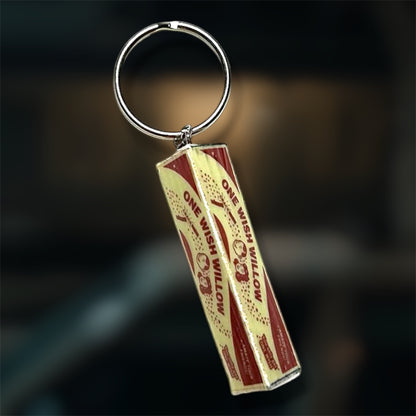 An Obsession-inspired One Wish Willow box replica keychain on a blurry backgroud.