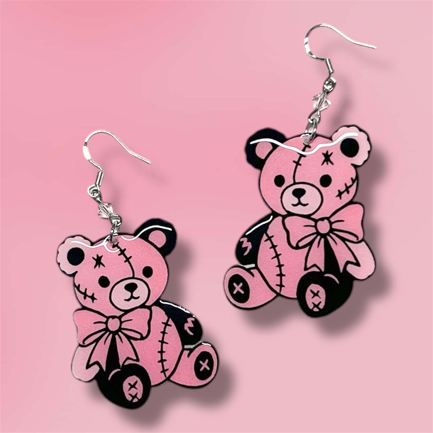 Pink and black teddy bear beaded resin statement earrings on a pink background