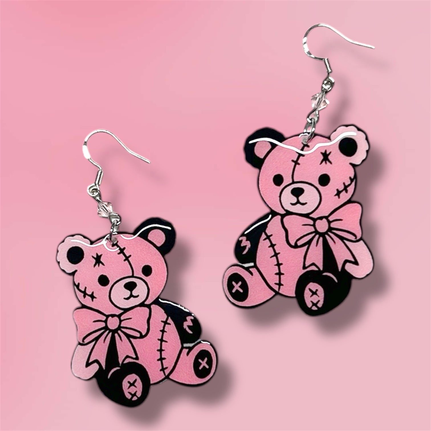 Pink and black teddy bear beaded resin statement earrings on a pink background