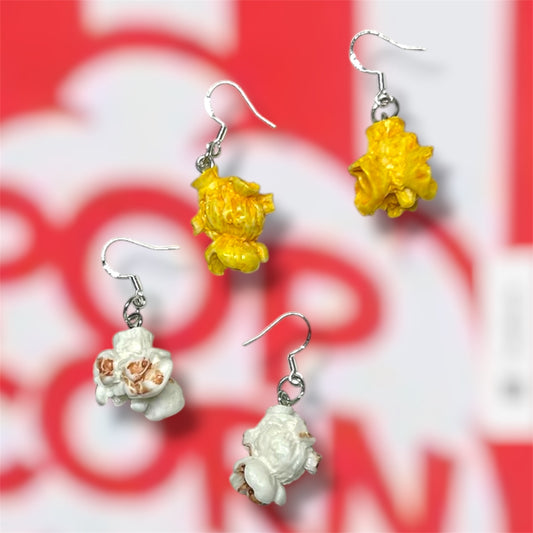 Buttered popcorn and plain popcorn dangle earrings on a red and white popcorn bucket background