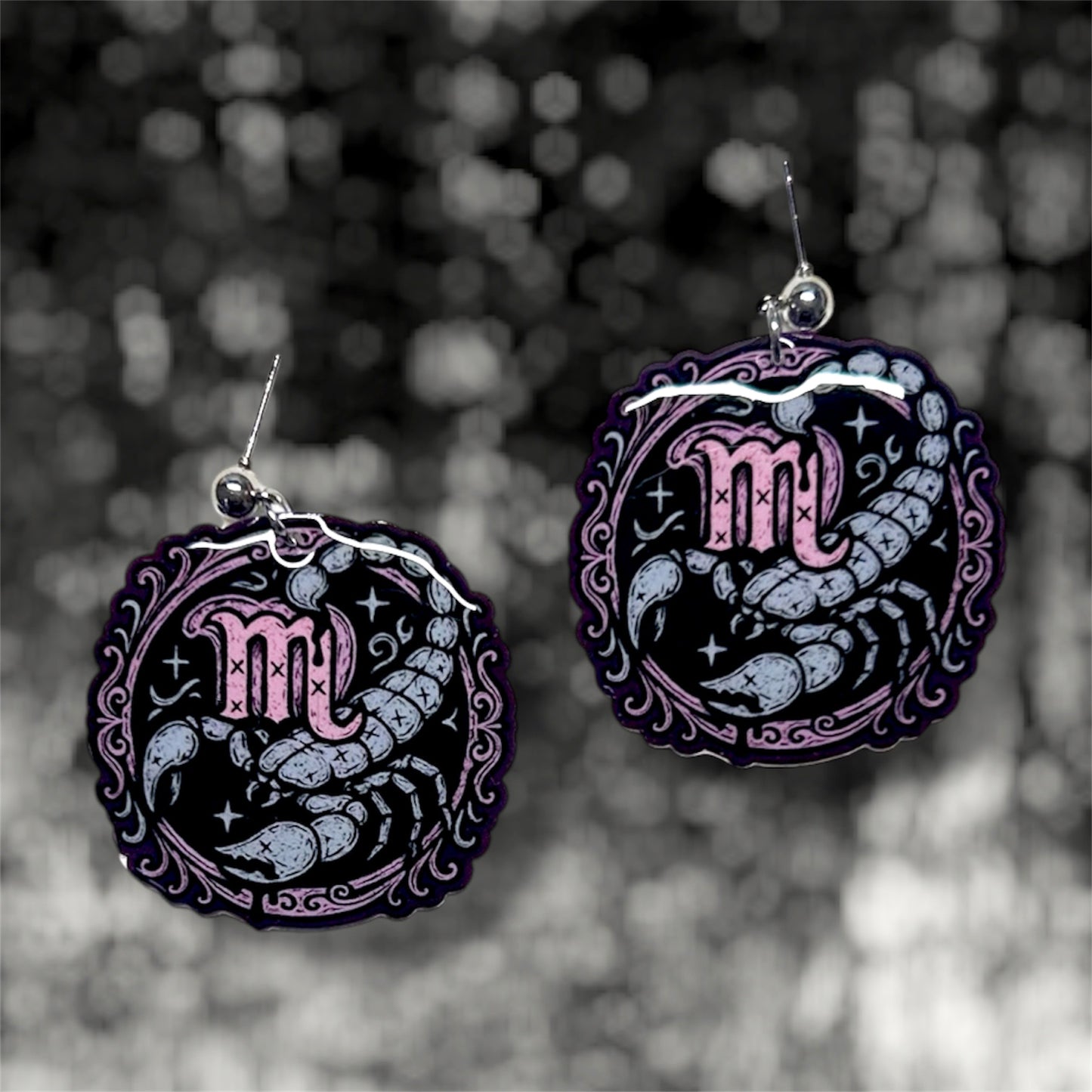 Scorpio zodiac sign scorpion resin dangle earrings on a blurry black and white background