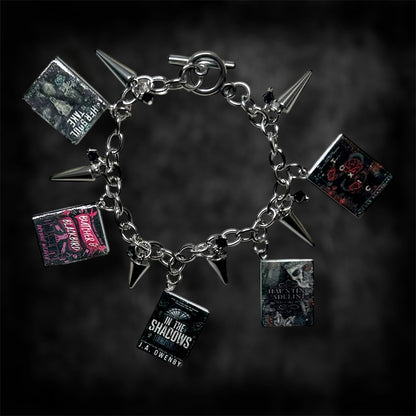 Smut book charm bracelet on a blurred black distressed background