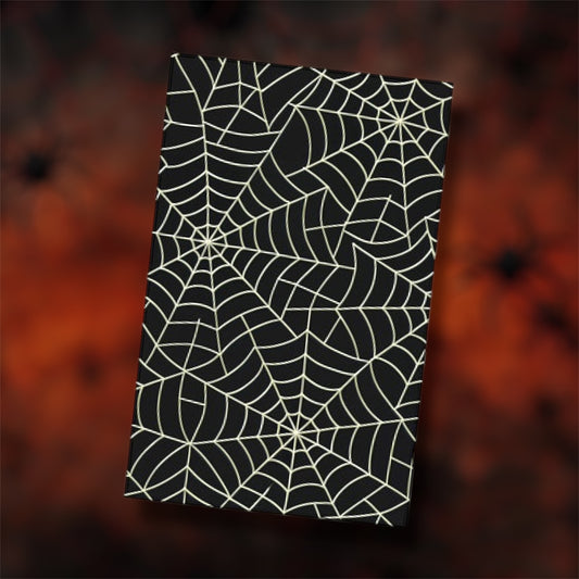 Black and white spiderweb notebook on a blurry red and black background